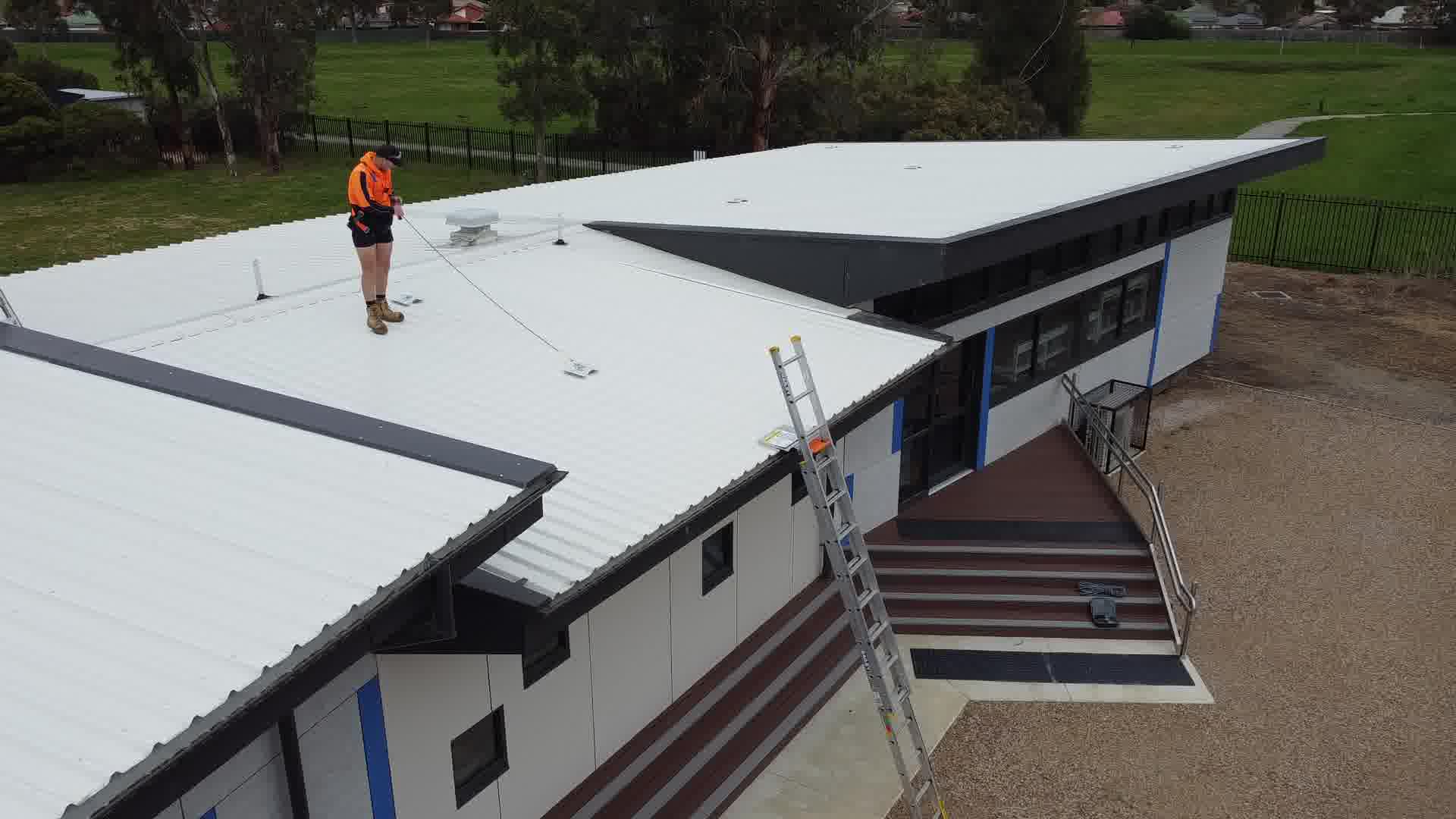 Technician inspecting the roof of a school building
