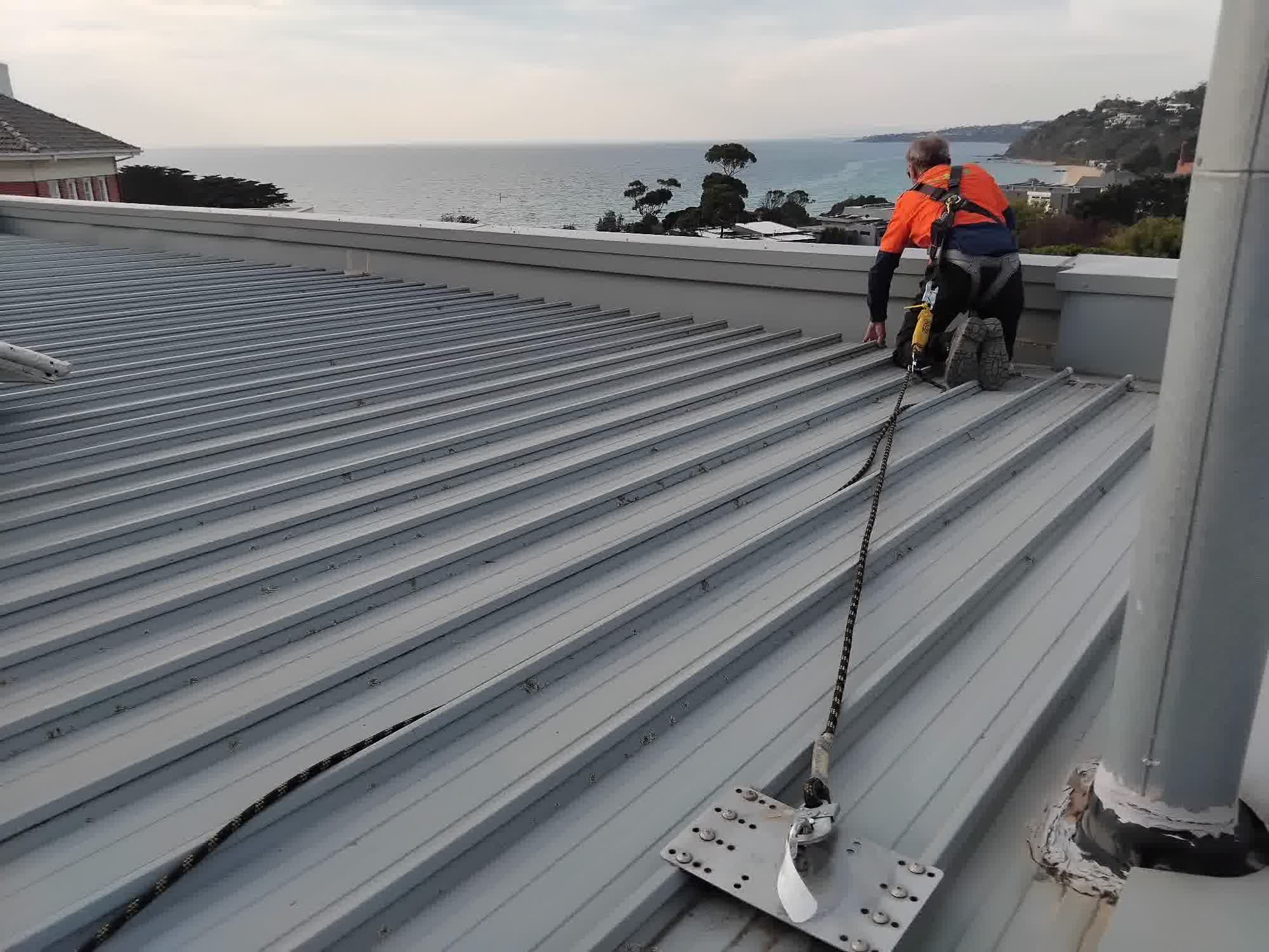 Technician inspecting a roof anchor point during a condition report